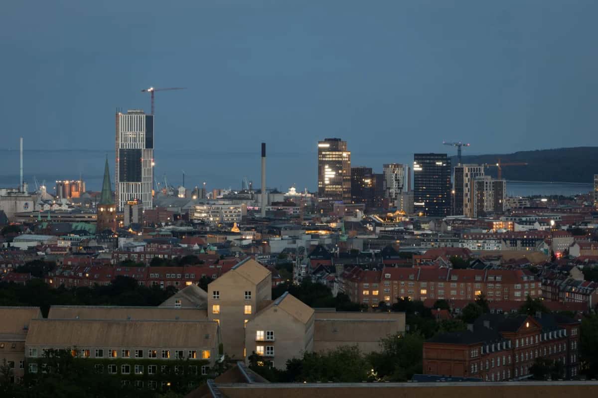 Aarhus au crépuscule vue depuis les hauteurs, toits du centre au premier plan, tours modernes et baie à l'arrière-plan