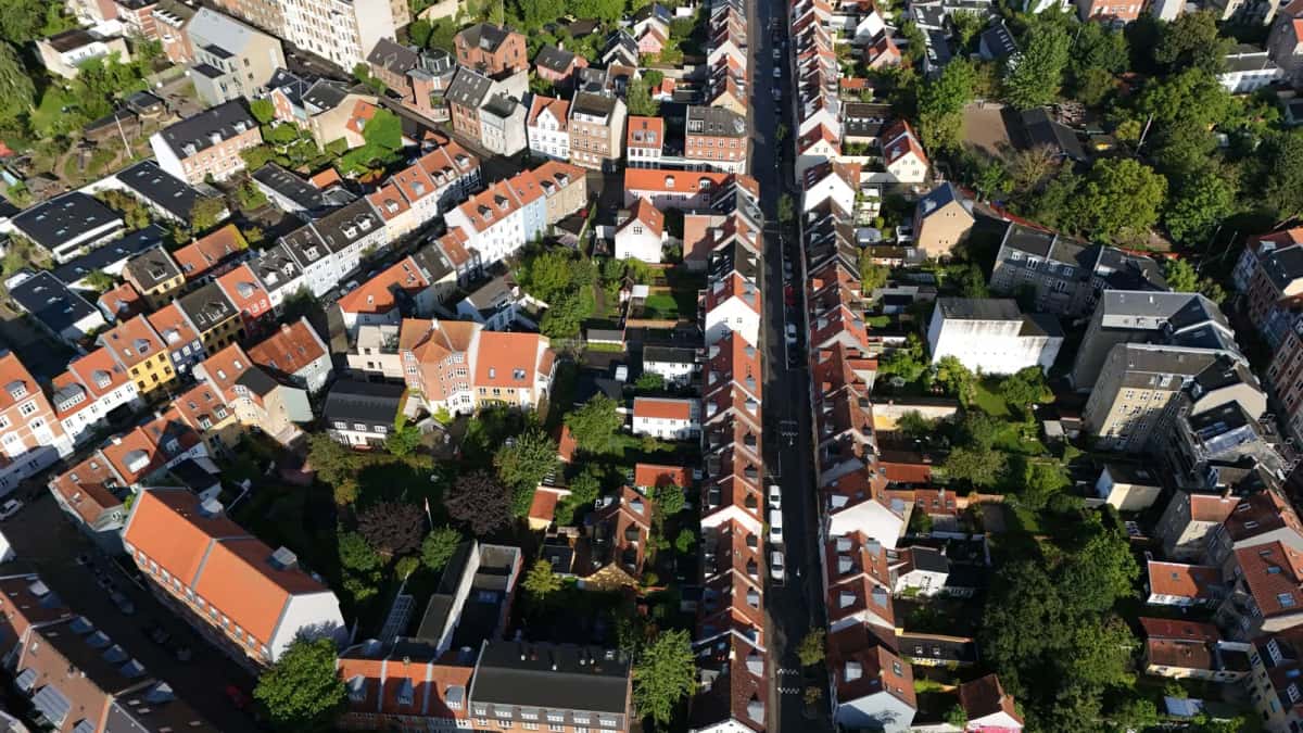 Vue aérienne d'un quartier résidentiel d'Aarhus, rangées de maisons aux toits de tuiles rouges et arbres entre les rues