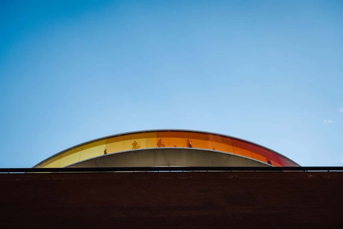 L'anneau de verre coloré Your Rainbow Panorama posé sur le toit de brique du musée ARoS, sous un ciel bleu