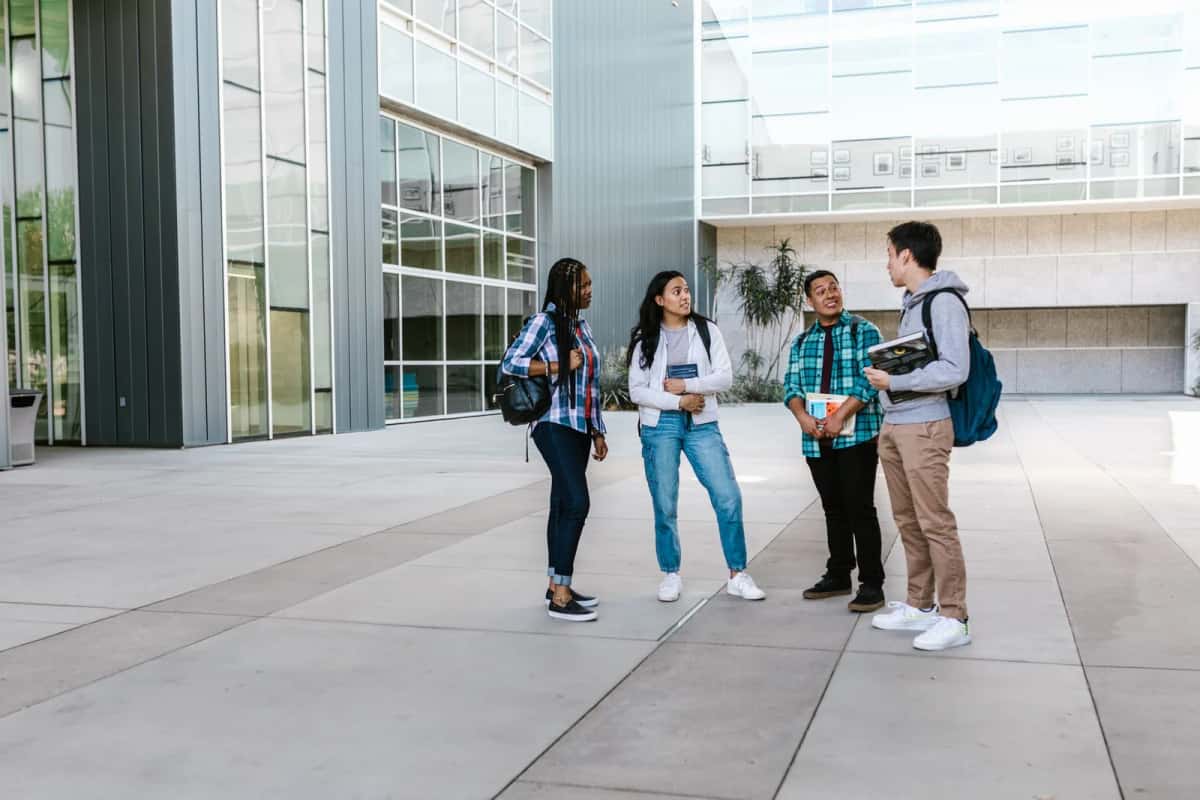Groupe d'étudiants en business school devant un campus universitaire moderne