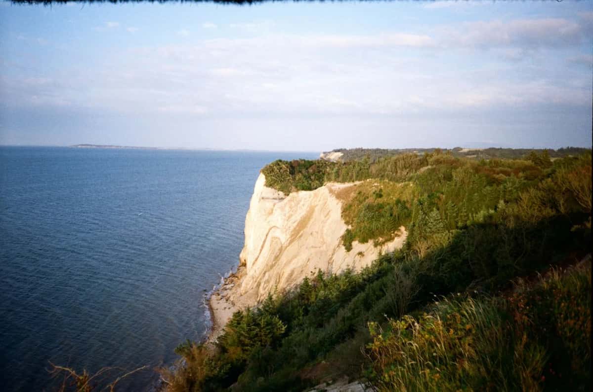 Falaise claire de l'île de Fur, dans le Limfjord au Danemark, herbes rases sur le rebord et eau du fjord jusqu'à l'horizon
