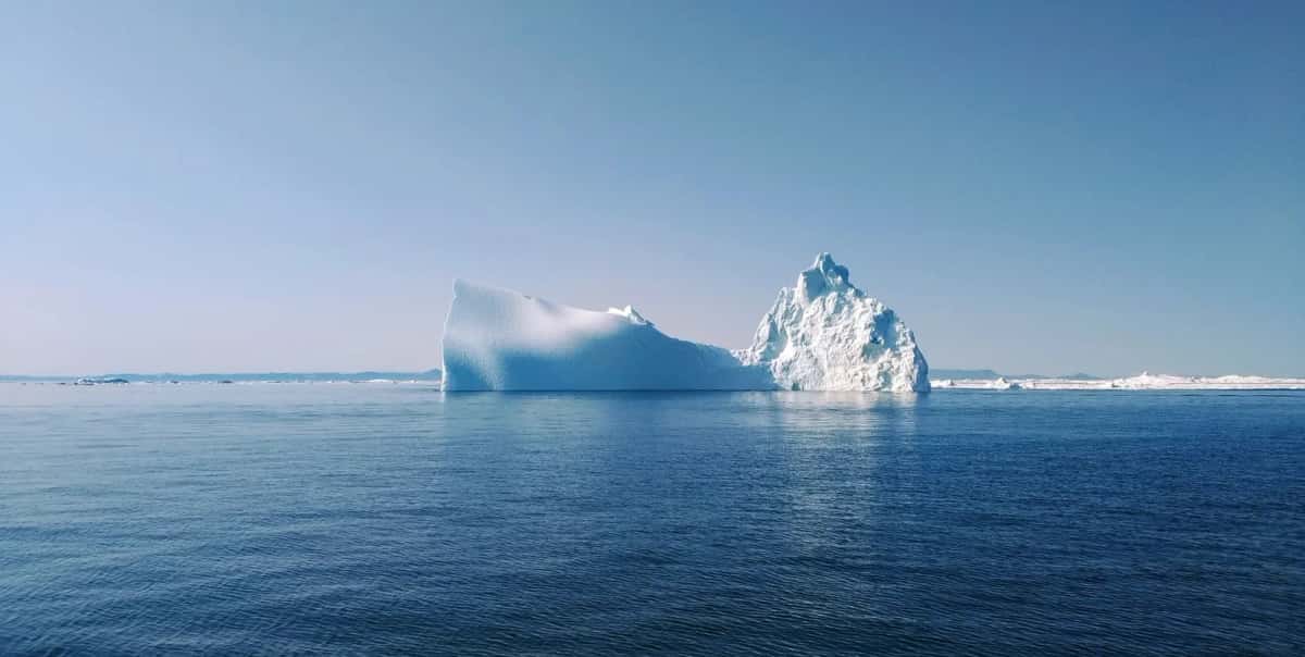 Iceberg dérivant sur une mer arctique bleue au large du Groenland