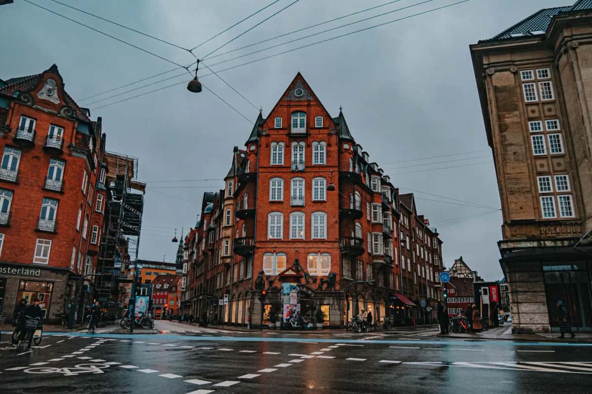 Rue pavée d'Indre By, le centre historique de Copenhague, avec immeubles anciens en brique et pistes cyclables