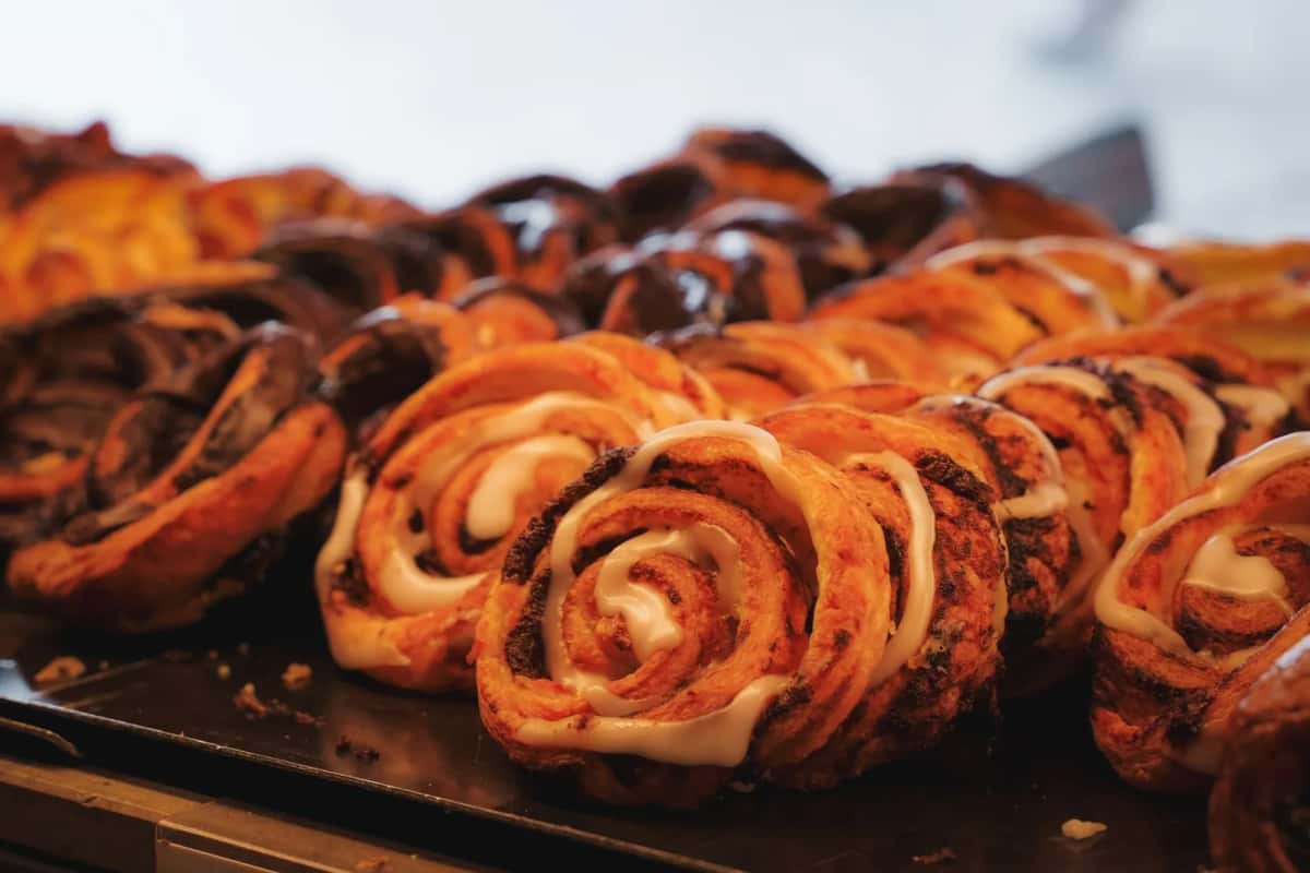 Plateau de brioches roulées à la cannelle glacées, sorties du four et encore brillantes