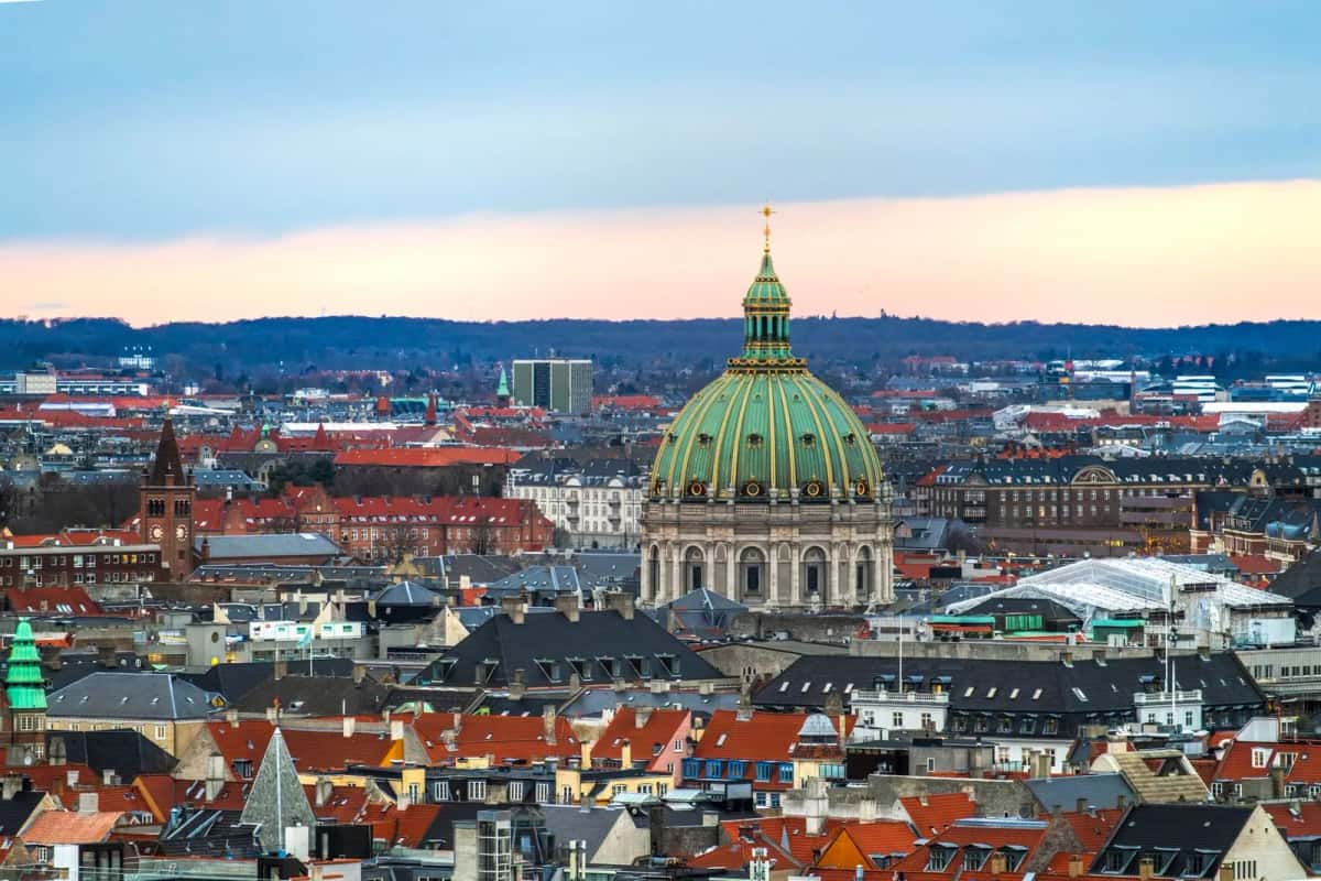 Le dôme vert-de-gris de l'église de marbre dominant les toits de tuiles rouges de Copenhague, vu de loin en fin de journée