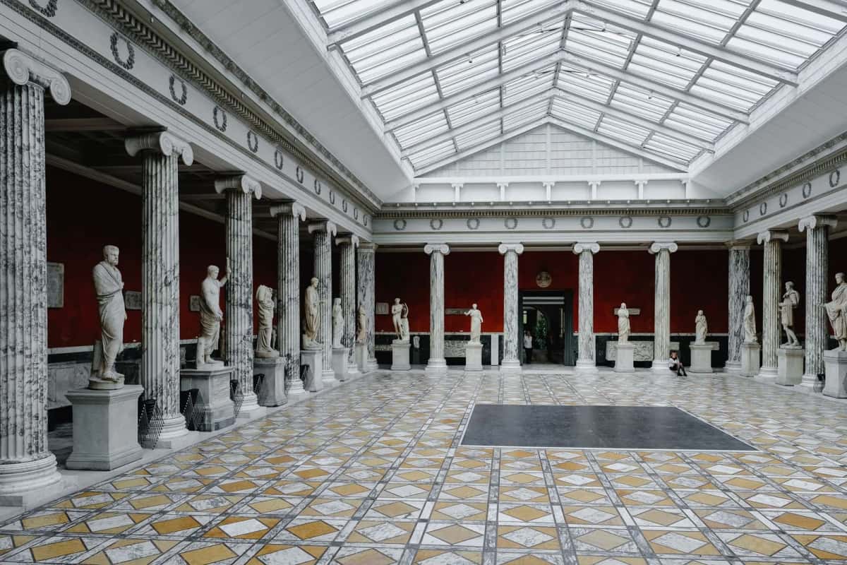 Galerie de sculptures antiques aux murs rouges de la Ny Carlsberg Glyptotek à Copenhague
