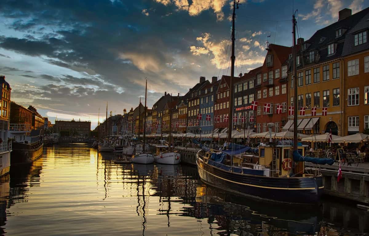 Le canal de Nyhavn à l'heure bleue, terrasses éclairées et voiliers amarrés le long du quai