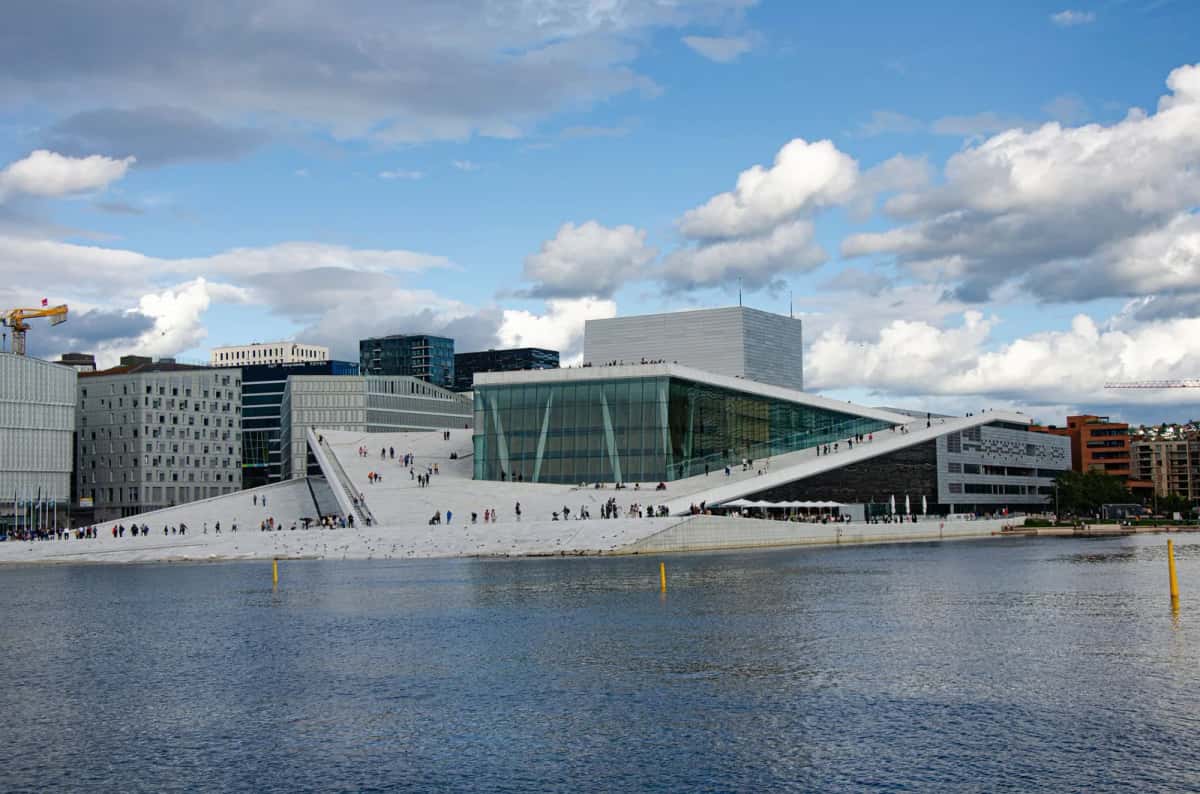 L'Opéra d'Oslo, grand plan incliné de marbre blanc sortant de l'eau du fjord, parcouru de promeneurs
