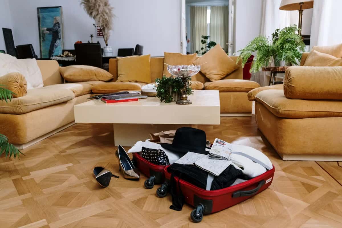 Valise ouverte en cours de préparation dans un salon avant un départ à l'étranger