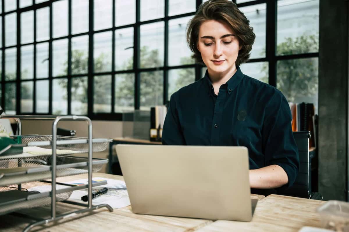 Professionnel international travaillant sur un ordinateur portable dans un bureau lumineux