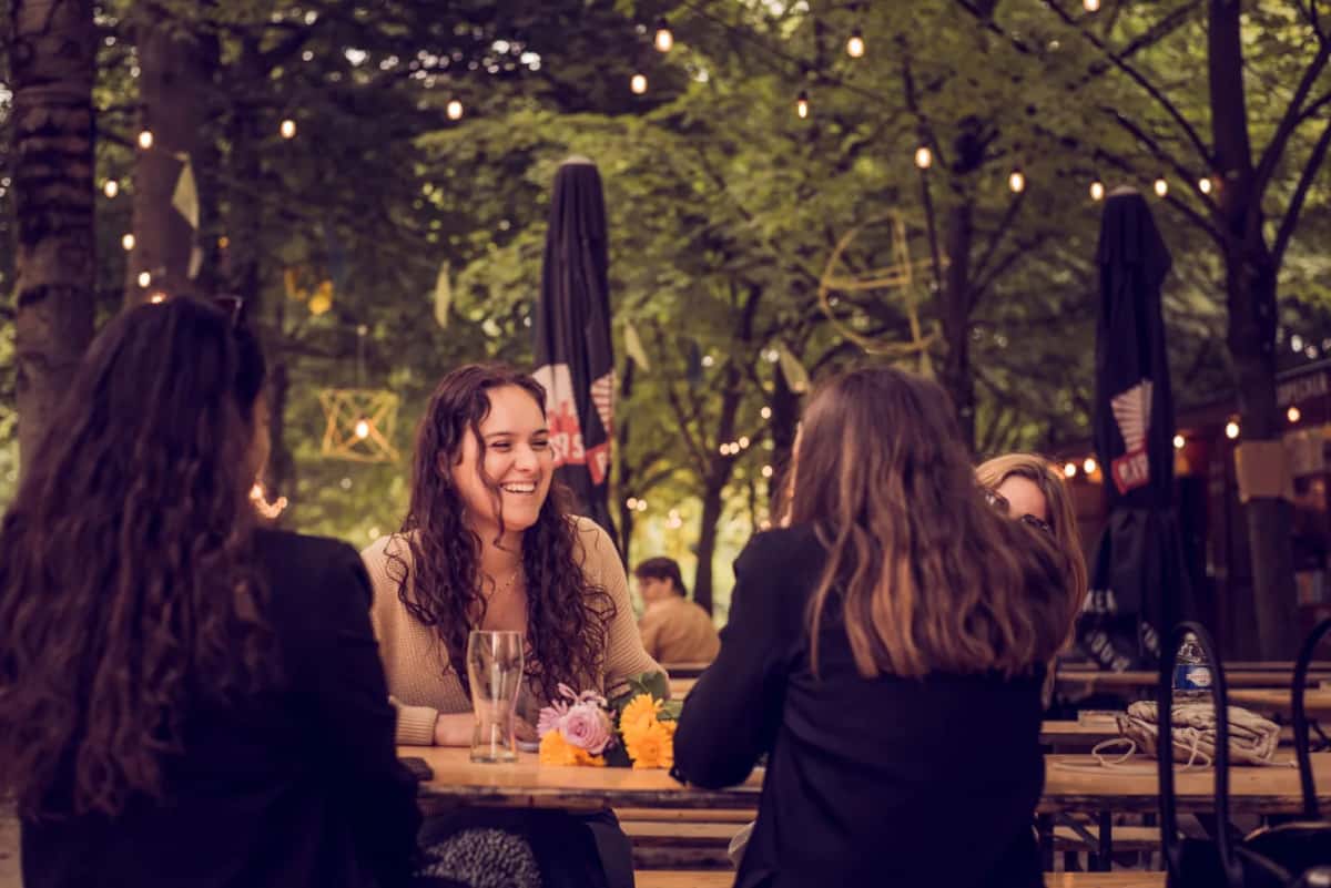 Groupe d'amis réunis autour d'une table en terrasse lors d'un rassemblement convivial
