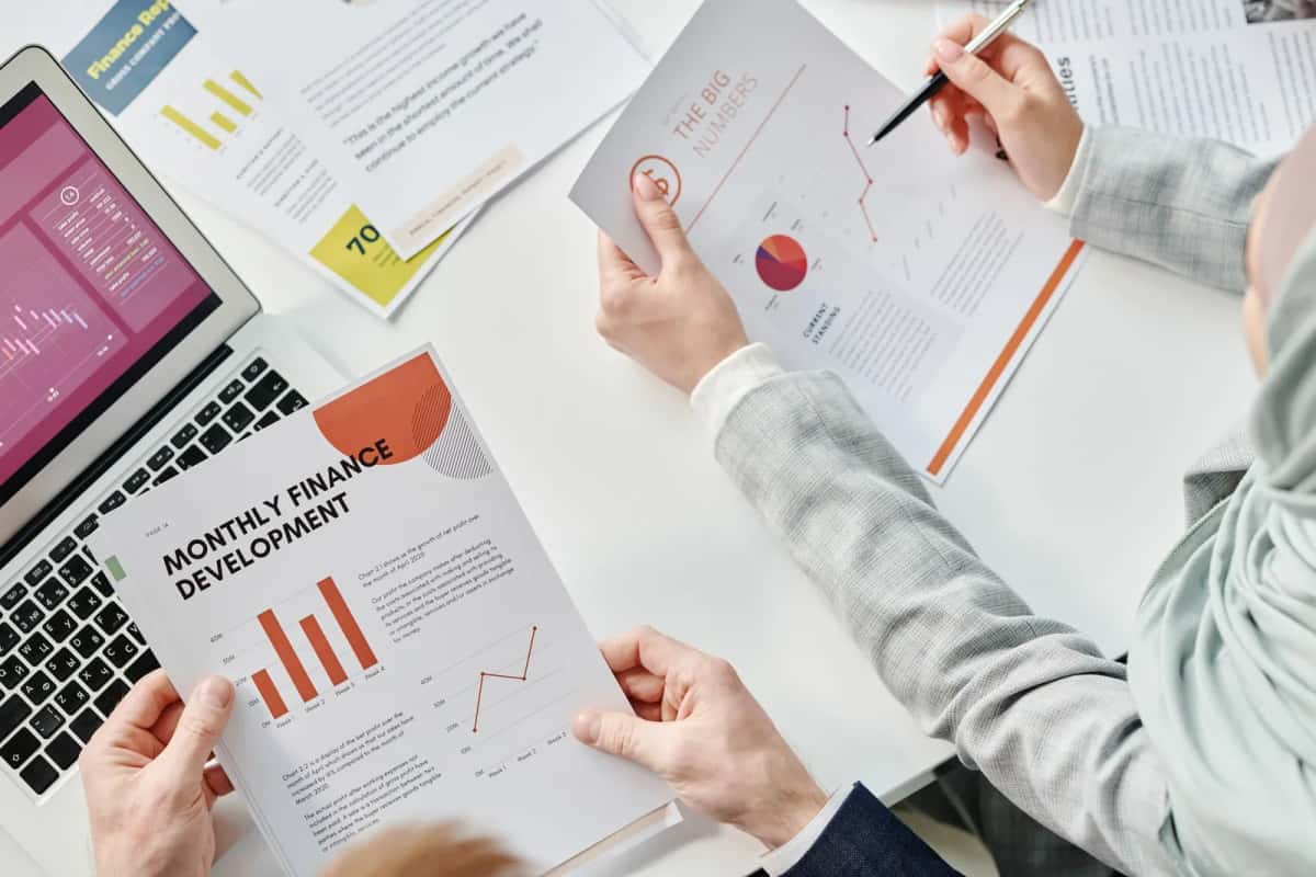 Réunion d'affaires autour de rapports financiers et d'un tableau de bord comptable