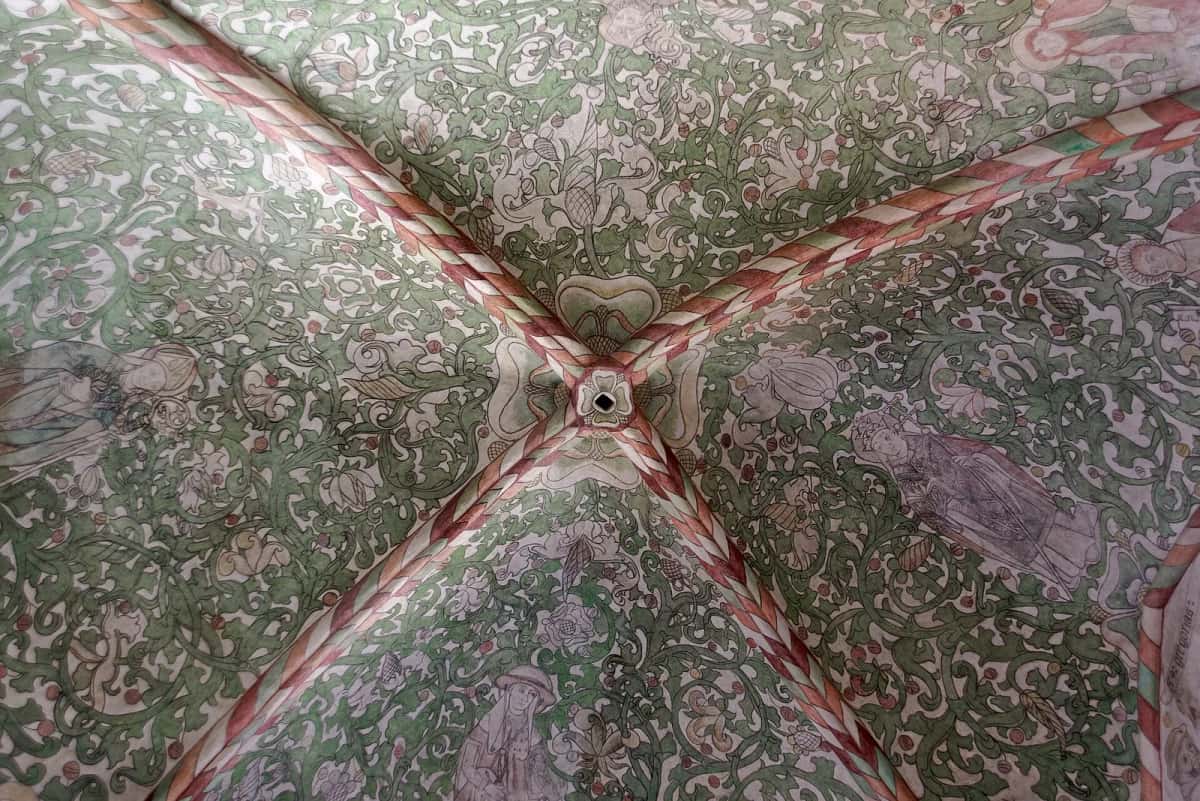 Voûte d'ogives de la cathédrale de Roskilde, entièrement couverte de fresques de feuillages et de figures en rouge et vert