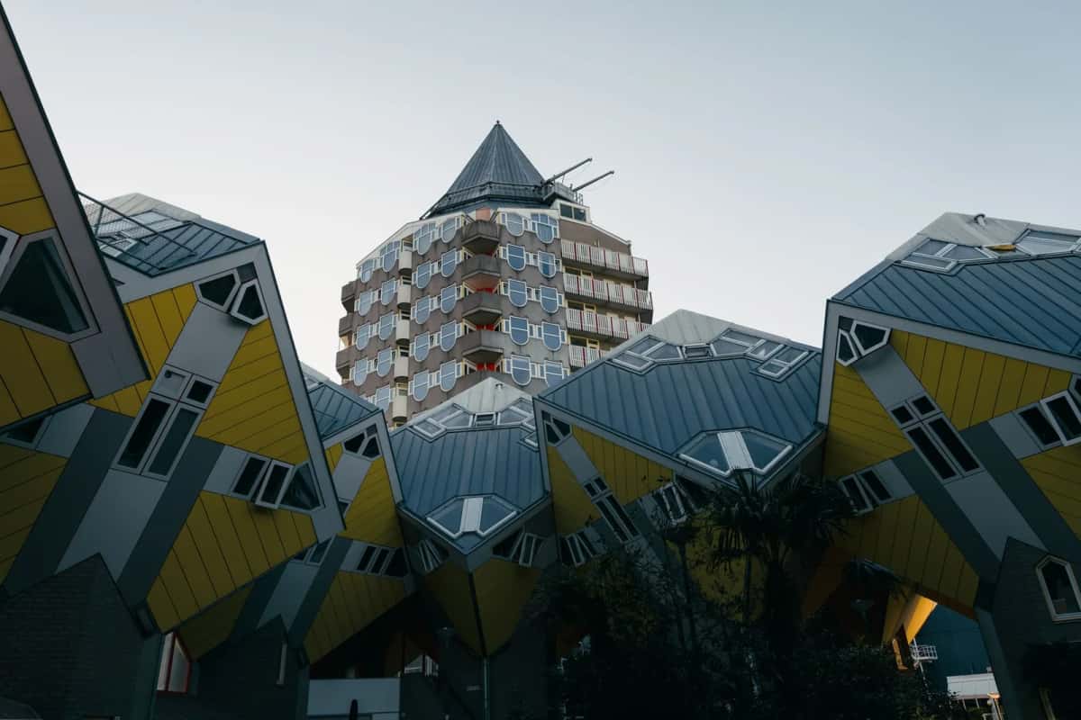 Les maisons cubiques jaunes de Rotterdam, inclinées sur leur pointe, devant la tour crayon