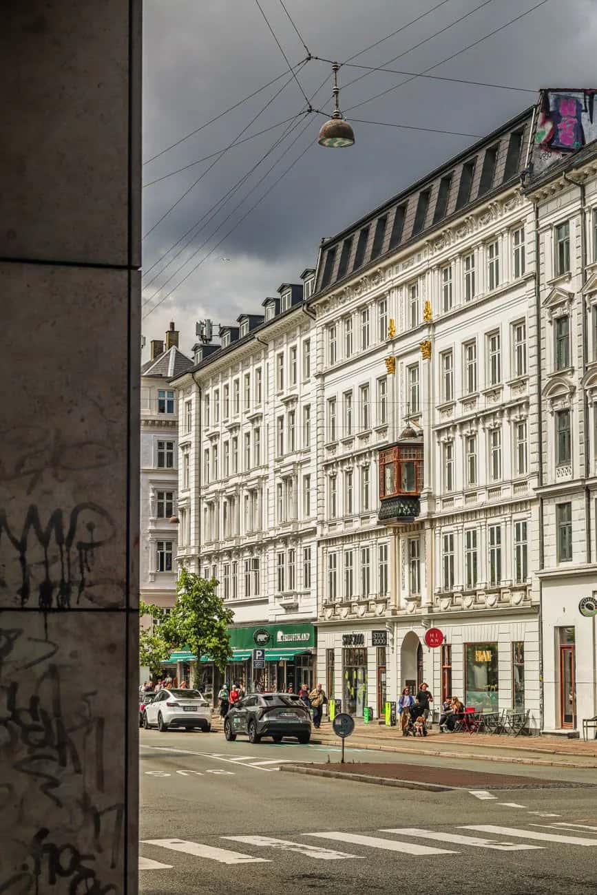 Rue résidentielle de Nørrebro à Copenhague avec façades du XIXe siècle, terrasses de café et pistes cyclables