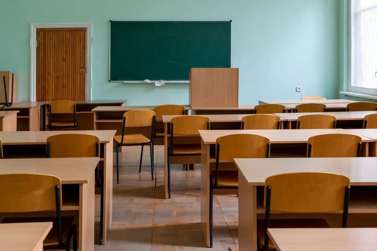 Salle de classe avec pupitres en bois et tableau vert