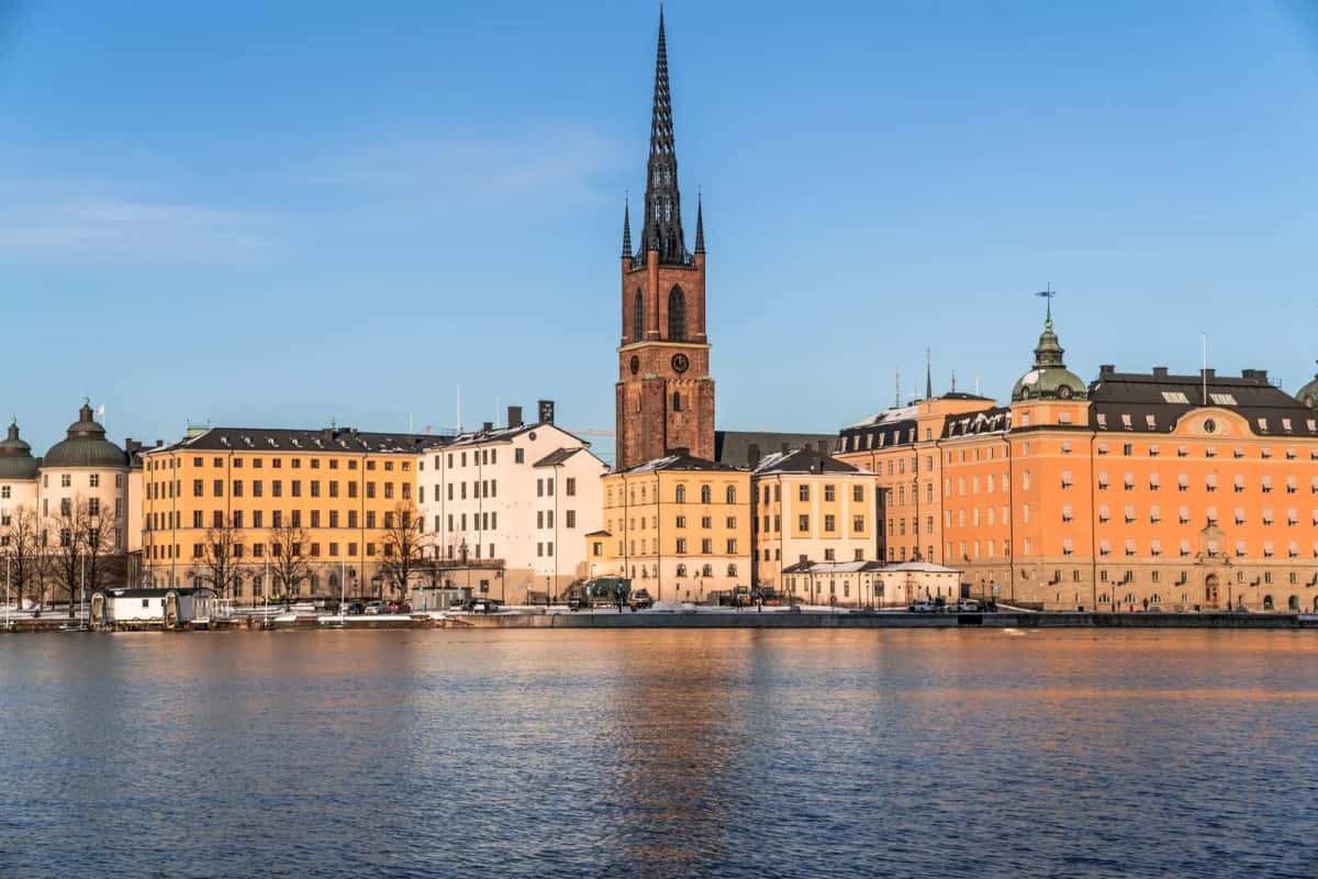 Front de mer de Riddarholmen à Stockholm, façades ocre alignées et flèche ajourée en fonte de l'église Riddarholmen