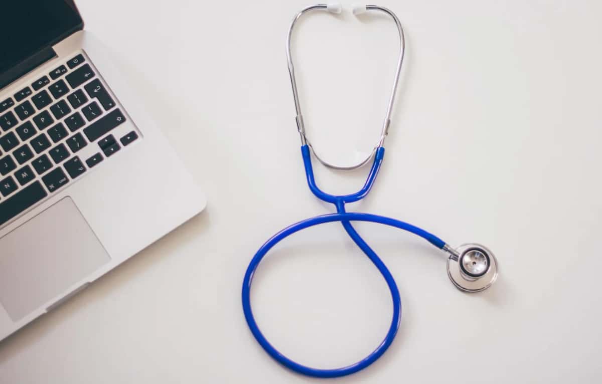 Stéthoscope et ordinateur portable sur un bureau, symbole de l'accès aux soins au Danemark