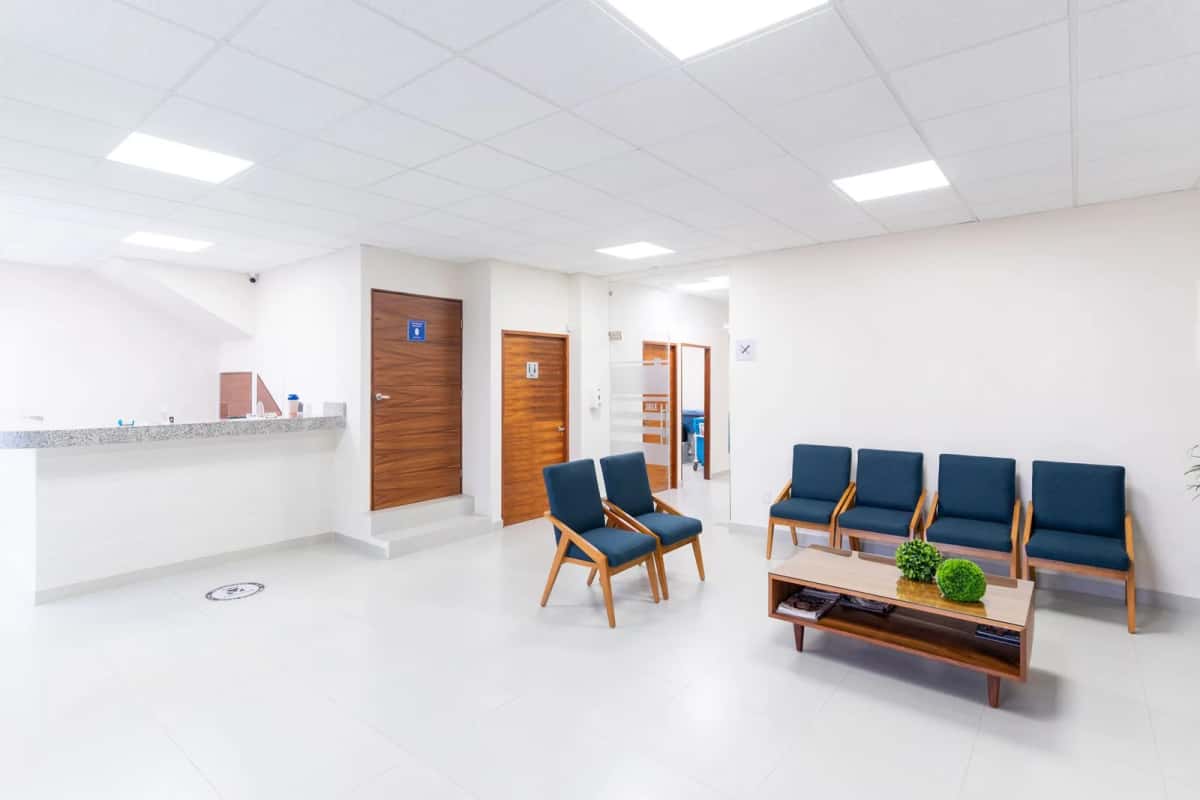 Salle d'attente d'une clinique, fauteuils et comptoir d'accueil