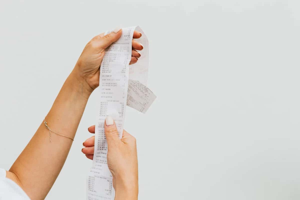 Ticket de caisse tenu en main illustrant la TVA sur les achats du quotidien