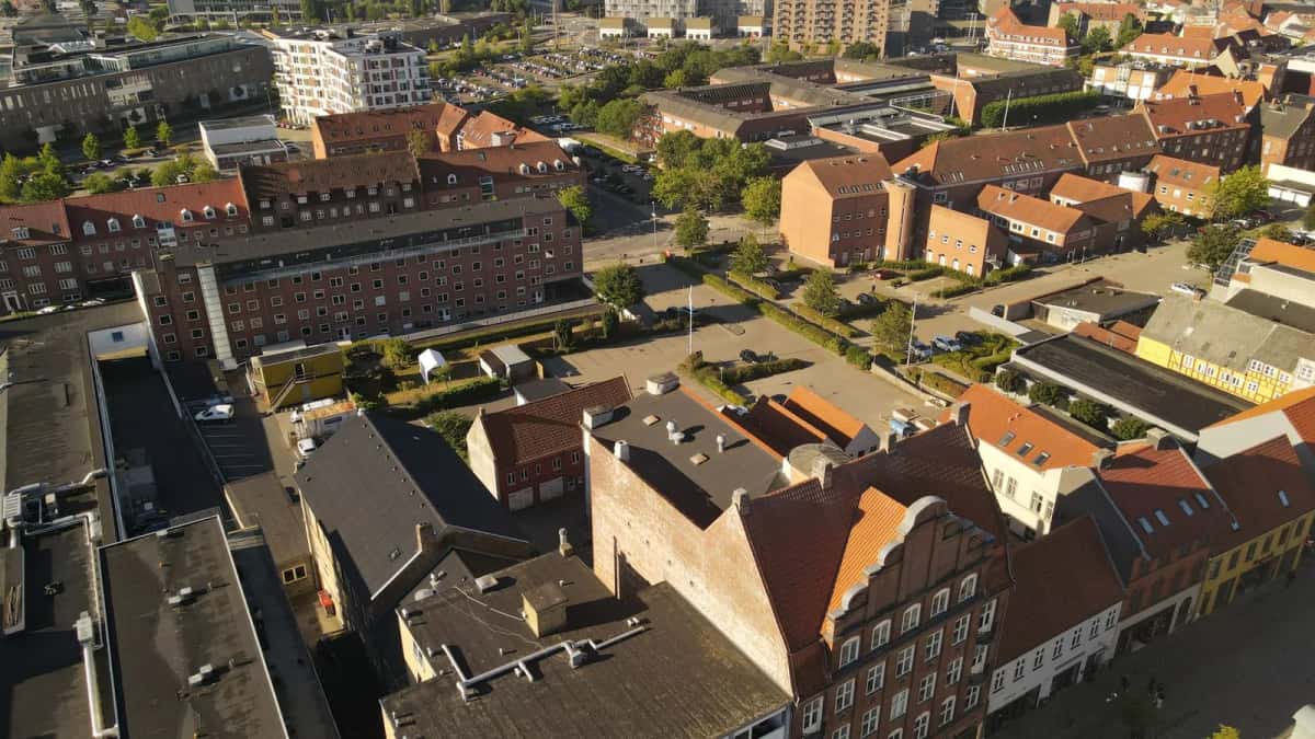 Vue plongeante sur les toits de tuiles rouges et les cours arborées d'une vieille ville danoise