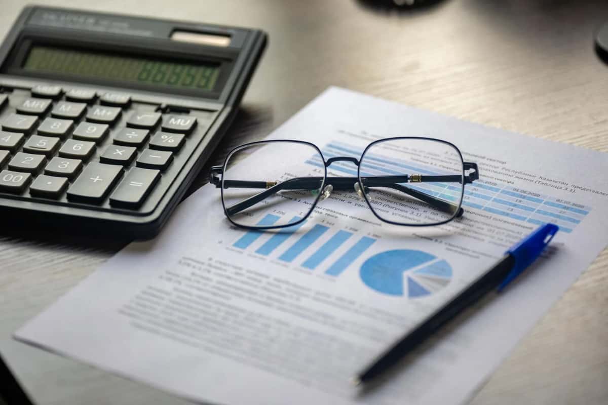 Calculatrice, lunettes et graphiques financiers illustrant les tranches d'imposition