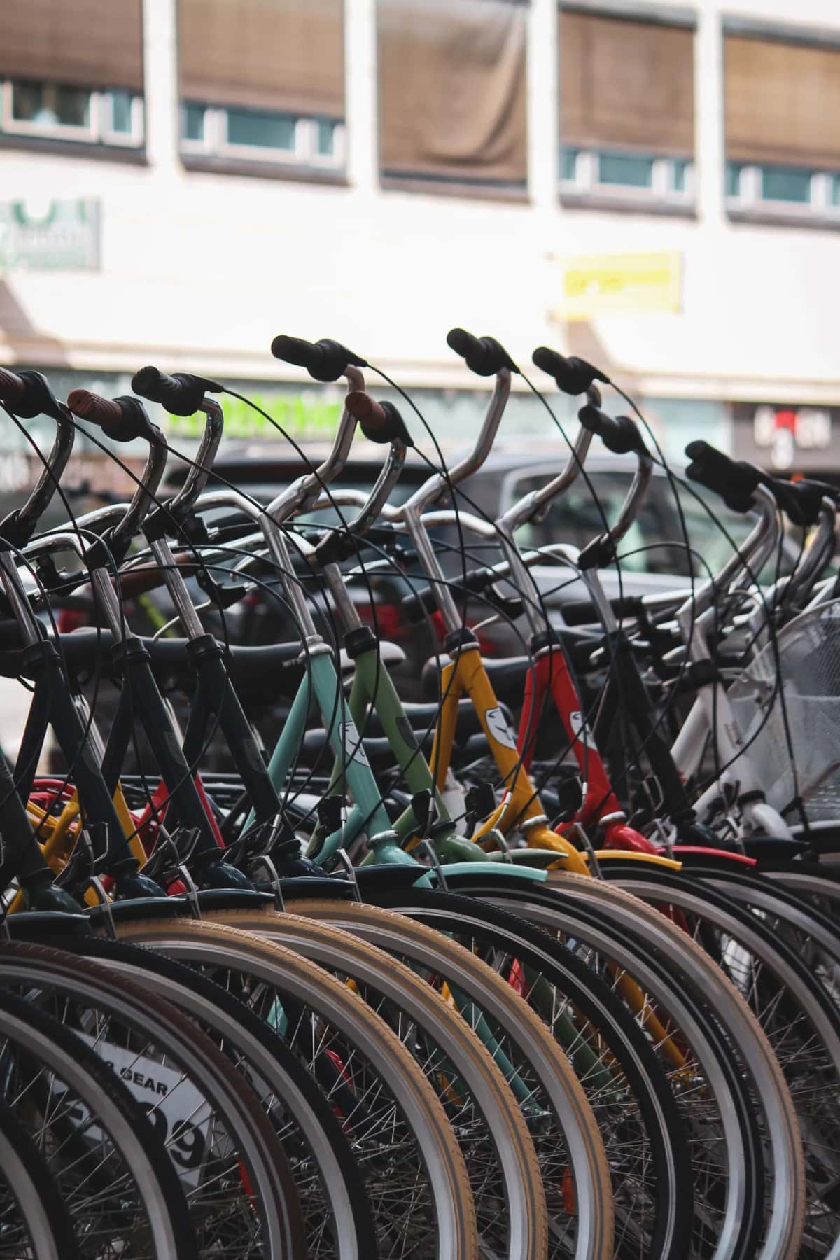 Rangée serrée de vélos de ville garés dans des râteliers, guidons et roues alignés