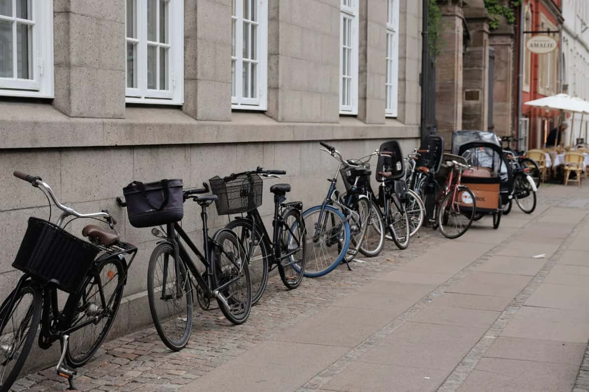 Rangée de vélos et vélos cargo garés le long d'une rue pavée de Copenhague