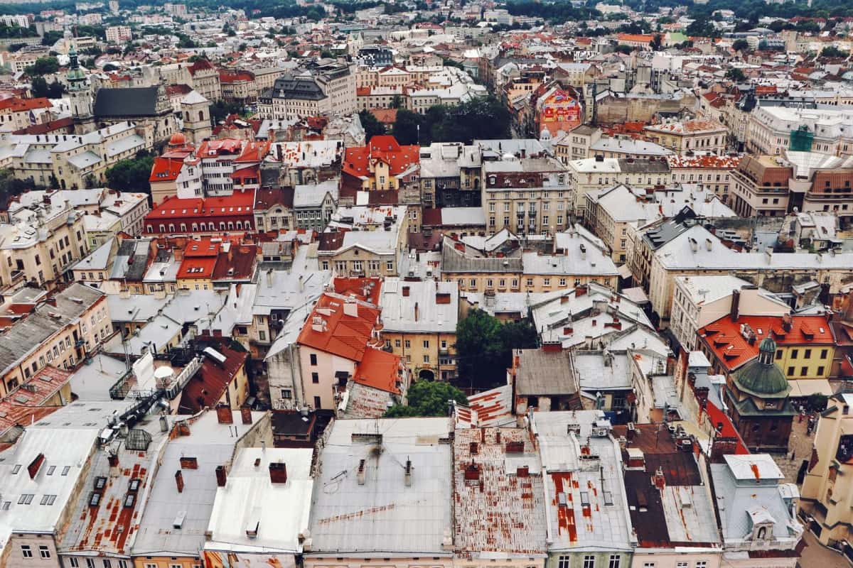 Vue aérienne de toits serrés d'une ville dense, tuiles rouges et terrasses à perte de vue
